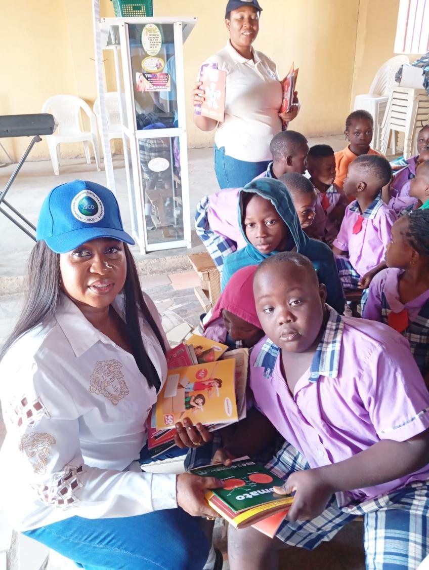 ISCD's chief executive with pupils receiving school materials